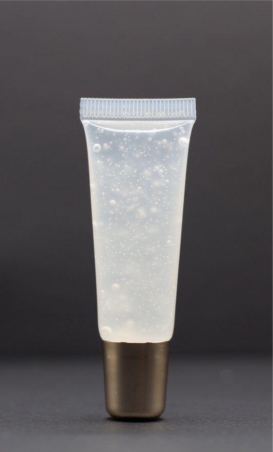 Clear high-shine vegan lip gloss with a pineapple and cotton candy scent, non-sticky and ultra-glossy for everyday wear.