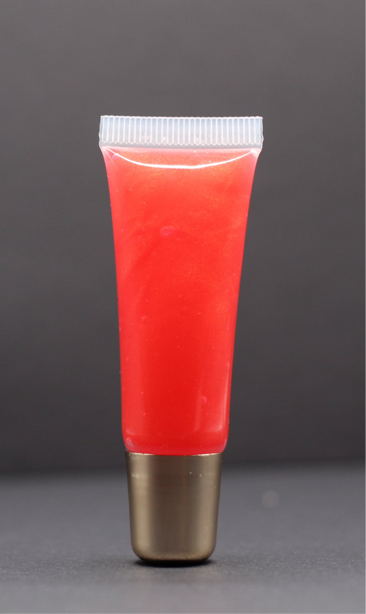 Pinkish red vegan lip gloss with a watermelon and strawberry scent, hydrating with a bold yet wearable tint and smooth finish.