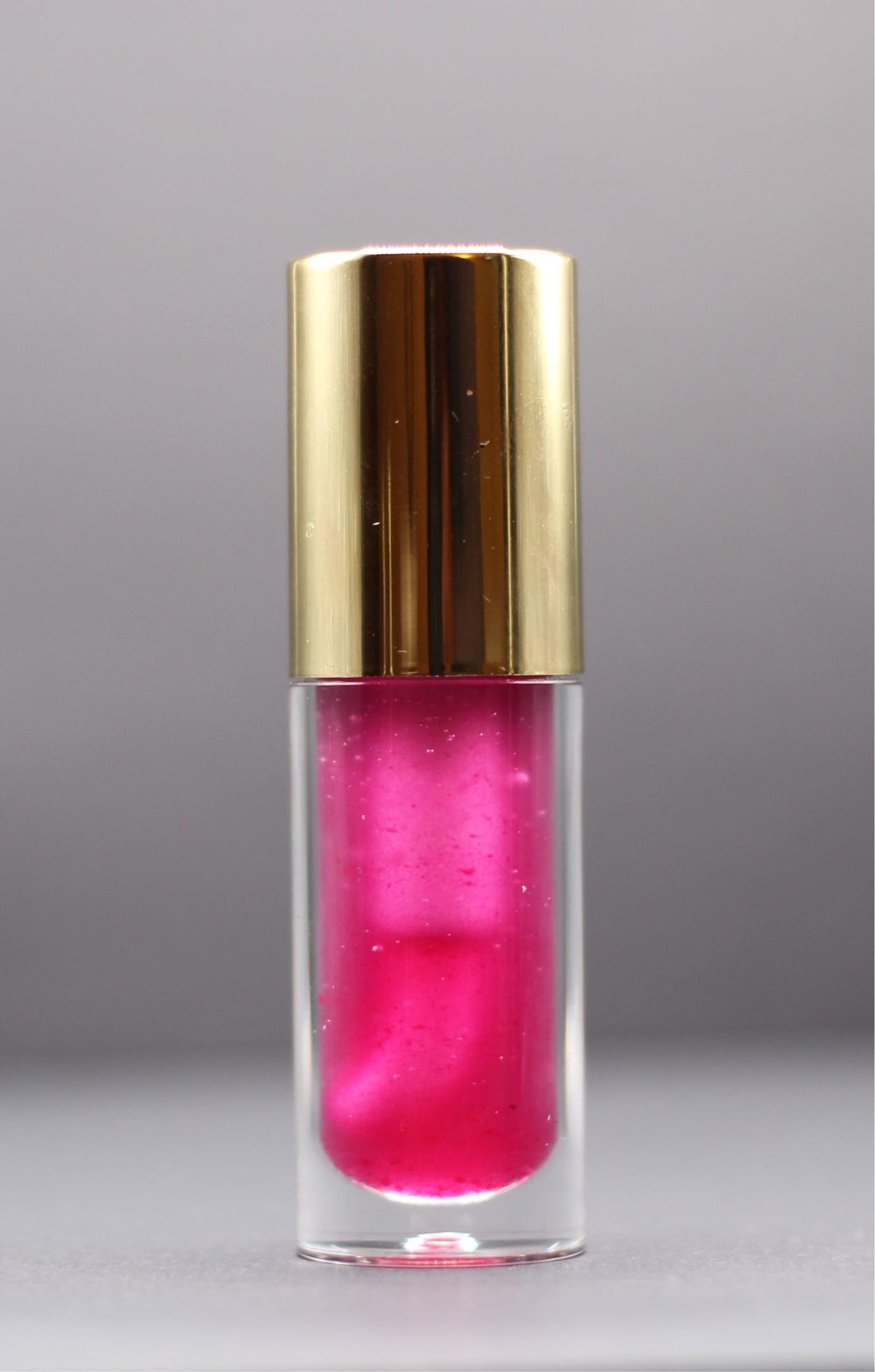 Sheer purple vegan lip oil, scented like cotton candy and designed for soft hydration and non-sticky shine.